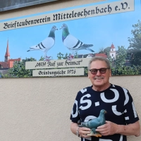 Schon seit Tag&nbsp;eins dabei: der Vorsitzende des Mitteleschenbacher Brieftaubenvereins, Ortwin Weiß. Zum 50. Geburtstag des Vereins ist ein neues Schild angefertigt worden. Die beiden Tauben auf dem Schild waren Weiß' erfolgreichste Weibchen. (Foto: Antonia Müller)