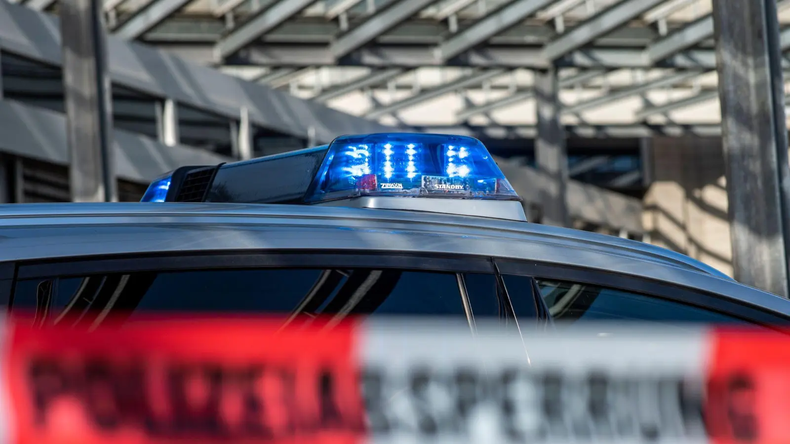 Ein Polizei-Blaulicht leuchtet über einem Absperrband mit der Aufschrift „Polizeiabsperrung“. (Foto: David Inderlied/dpa/Illustration)