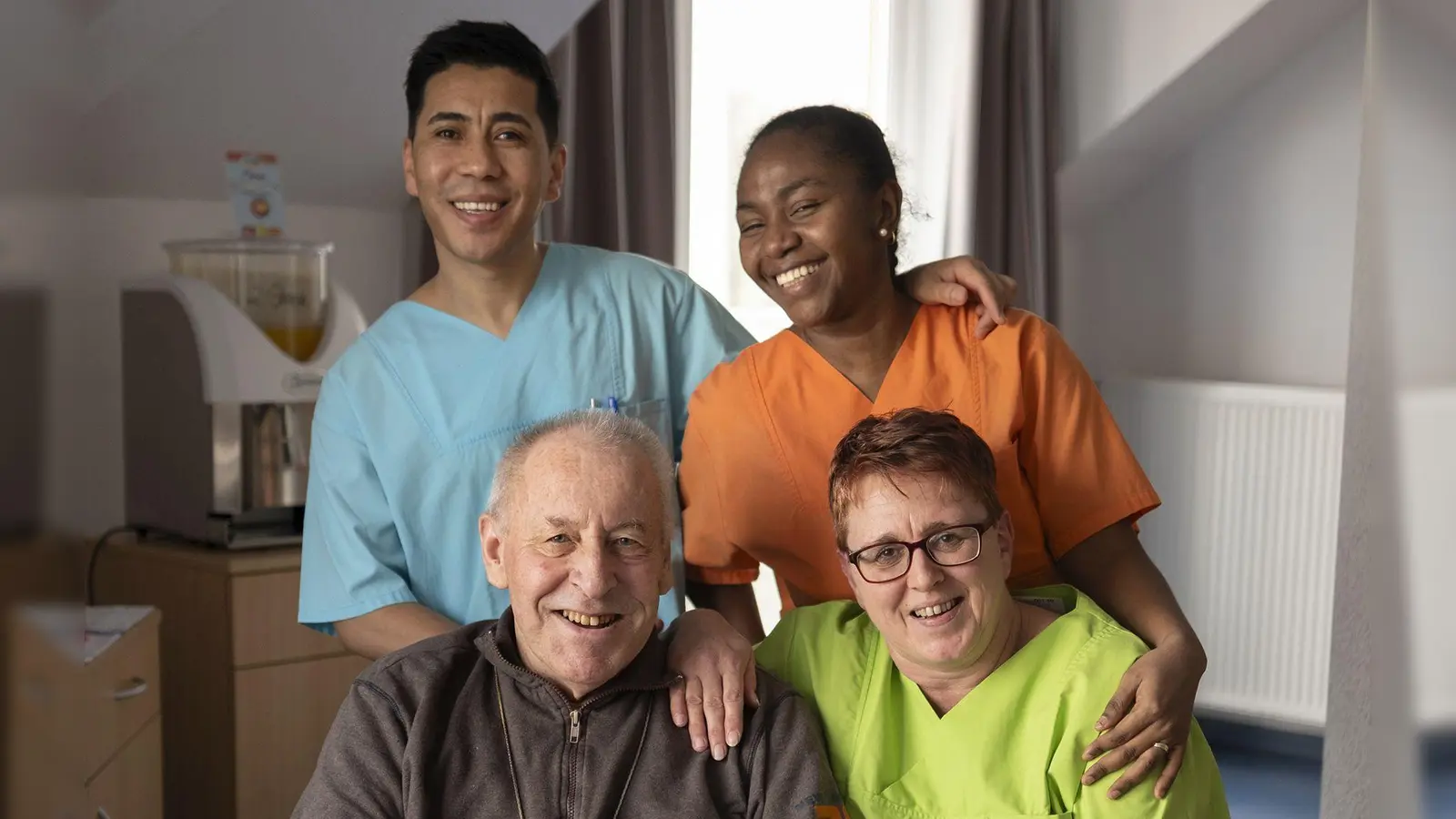 Asif Mehrdadi (Afghanistan, oben links) mit seinen Kolleginnen Marie Razafinandrazana aus Madagaskar (oben rechts) und Karin Schmidt (unten rechts) sowie Eduard Zwanzger, der schon seit 20 Jahren im Bad Windsheimer Vitalis-Wohn- und Pflegeheim lebt. (Foto: Andreas Riedel)