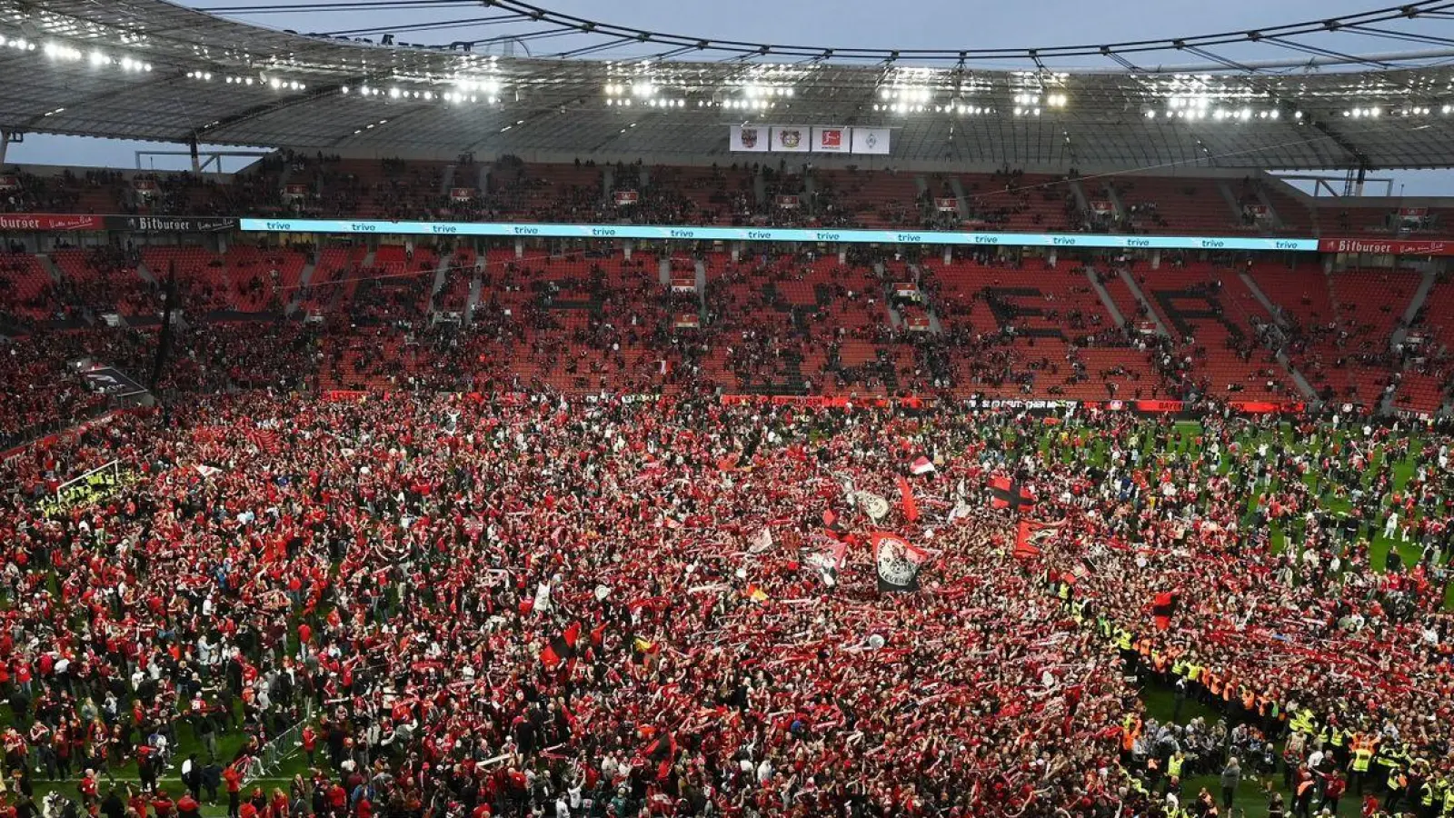 Leverkusens Fans bejubeln auf dem Rasen den Gewinn der Deutschen Meisterschaft. (Foto: David Inderlied/dpa)