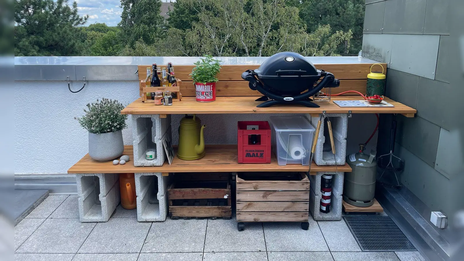 Mit einigen Dielen und Mauersteinen kann man selbst eine Grillstation bauen und an die individuellen Bedürfnisse anpassen. (Foto: DIY Academy/dpa-tmn)