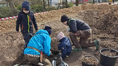 Landrat Dr. Christian von Dobschütz (rechts) und seine Kinder lassen sich von Streuobstberater Florian Kleinschroth in die Kunst des Bäumepflanzens einweisen. (Foto: Willi Schlicker)