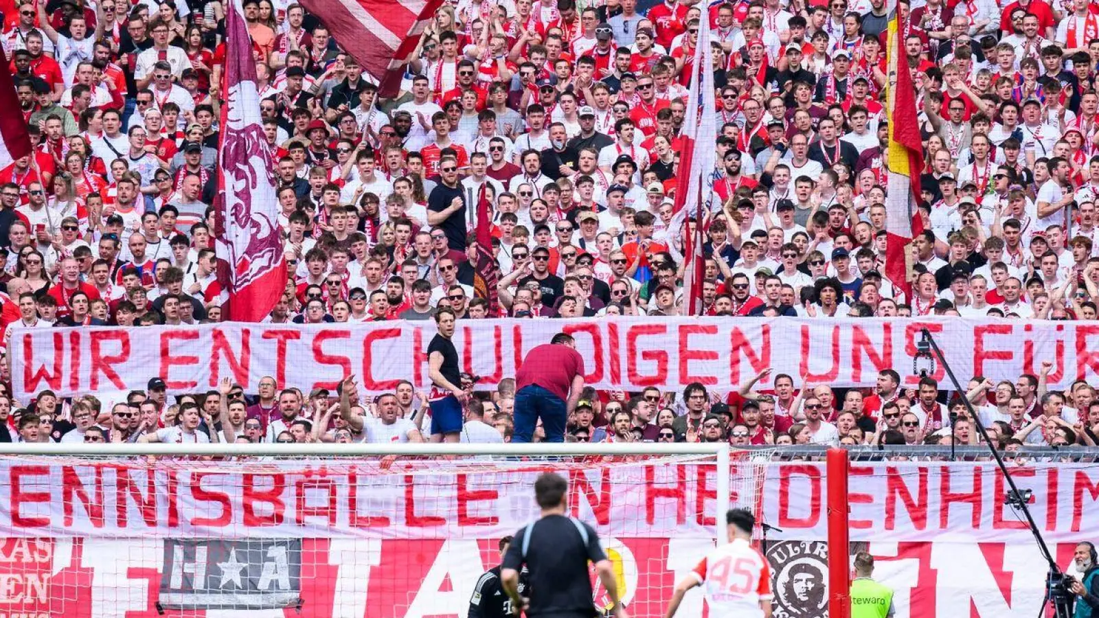 Die Bayern halten ein Transparent mit der Aufschrift „Wir entschuldigen und für die Tennisbälle in Heidenheim, Uli!“ in die Luft. (Foto: Tom Weller/dpa)