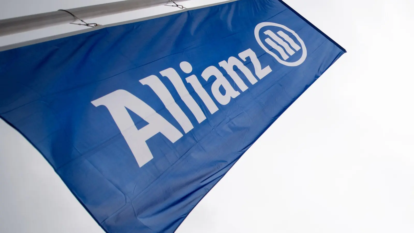 Eine Fahne mit dem Logo und dem Schriftzug der Allianz weht im Olympiapark. (Foto: Alexander Heinl/dpa/Symbolbild)