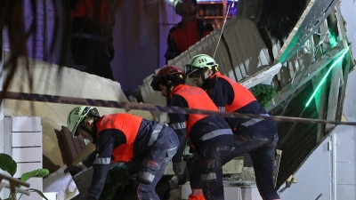 Rettungskräfte durchsuchen die Trümmer. (Foto: Isaac Buj/EUROPA PRESS/dpa)
