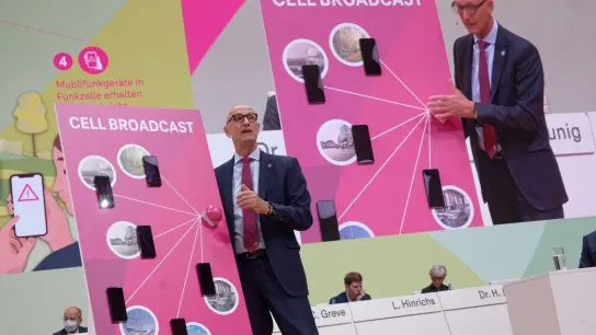 Der Vorstandvorsitzende der Deutsche Telekom, Timotheus Höttges, demonstriert bei der Hauptversammlung des Unternehmens im April das Cell Broadcast System. (Foto: Henning Kaiser/dpa)