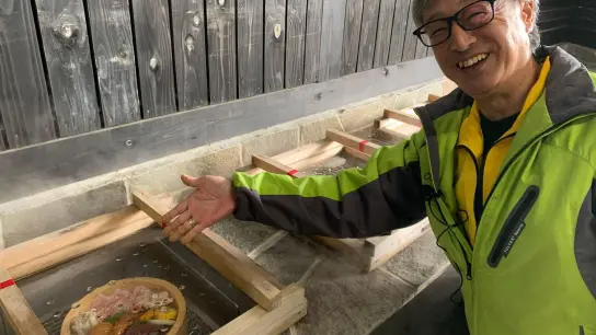 Hitoshi Tanaka, Chef des berühmten Hyotan Onsen, erklärt die traditionelle Kochmethode „Jigoku Mushi“ („Höllen-Gedämpftes“). (Foto: Lars Nicolaysen/dpa)