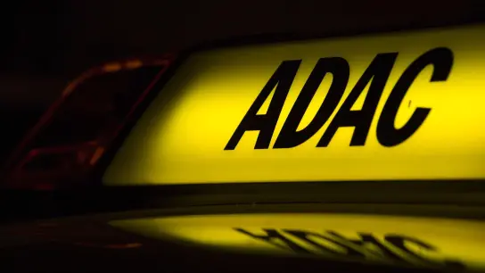 Die Abkürzung „ADAC“ auf einem Fahrzeug leuchtet in der Dunkelheit. (Foto: Monika Skolimowska/zb/dpa/Symbolbild)