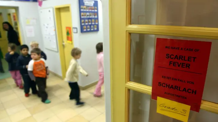 Ein Schild warnt vor Scharlach in einer  internationalen Vorschule in Berlin. (Symbolbild) (Foto: Tim Brakemeier/dpa)