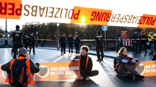 Aktivisten der Umweltschutzbewegung „Letzte Generation“ blockieren auf einer Straße in München den Verkehr. (Foto: Lennart Preiss/dpa)