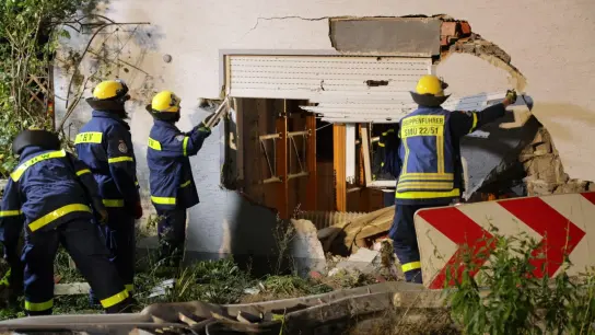 THW-Mitglieder arbeiten an der beschädigten Wand eines Wohnhauses. (Foto: Christoph Bruder/Bruder Media/dpa)