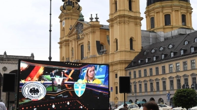 Ein großer Bildschirm steht vor den Stühlen des Cafehaus Tambosi um die Übertragung des Fußballspiels Deutschland - Schweden bei der Fußball-Weltmeisterschaft unter freiem Himmel auf dem Odeonsplatz vor der Theatinerkirche sehen zu können. (Foto: Felix Hörhager/dpa)