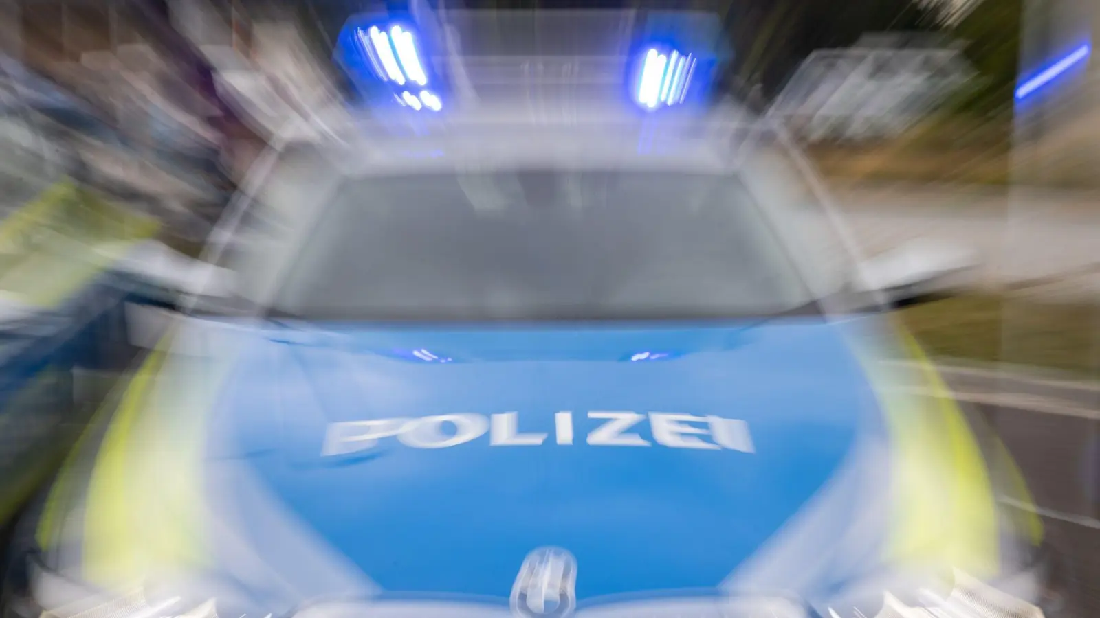 Ein Streifenwagen der Polizei mit eingeschaltetem Blaulicht. (Symbolbild: Daniel Karmann/dpa)