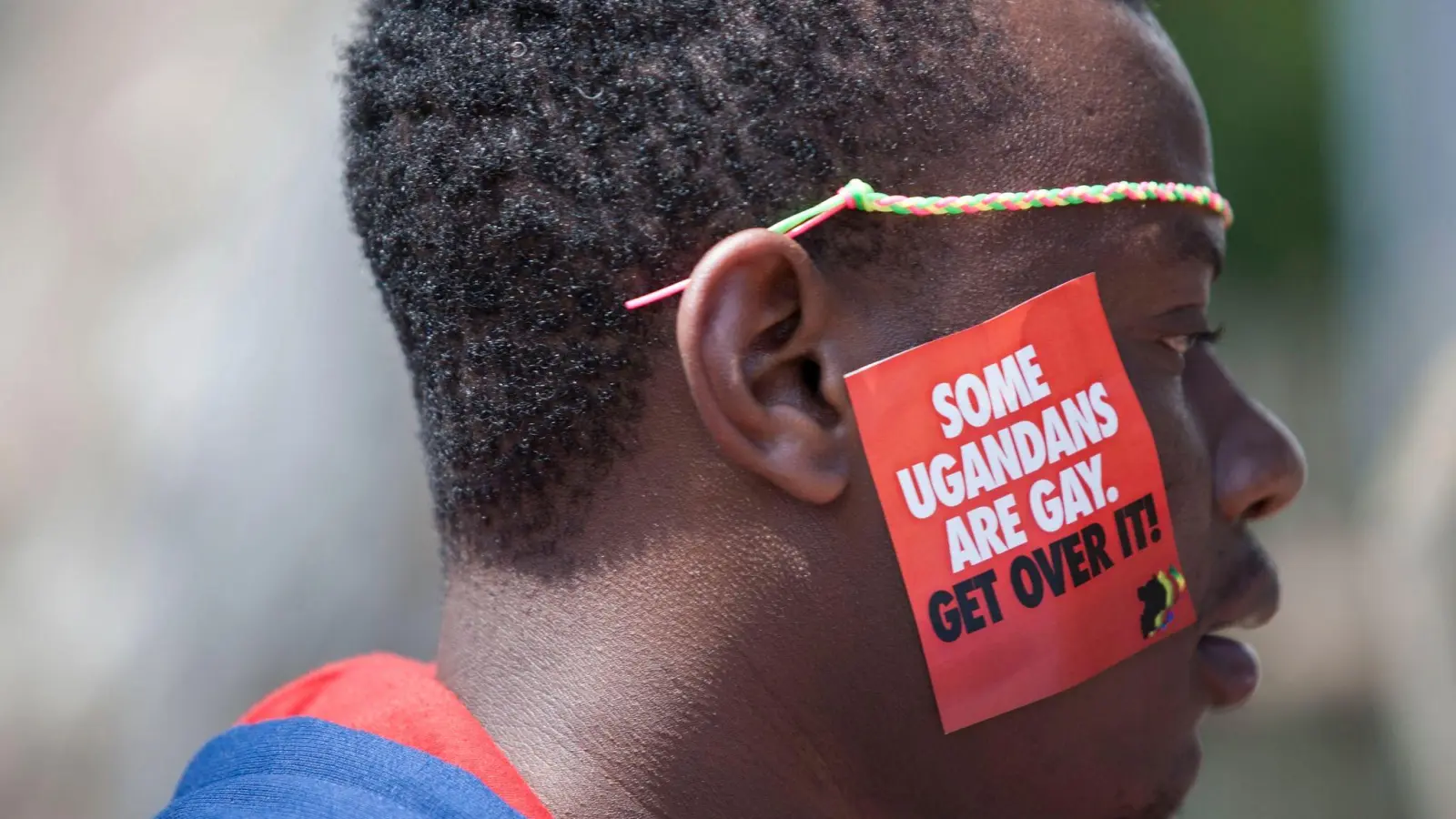Ein Mann trägt bei LGBT-Pride-Feierlichkeiten in Entebbe einen Aufkleber mit der Aufschrift „Einige Ugander sind schwul. Finde dich damit ab“ (Archivbild). Das ugandische Parlament hat für ein strenges Anti-Homosexuellengesetz votiert. (Foto: Rebecca Vassie/AP/dpa)