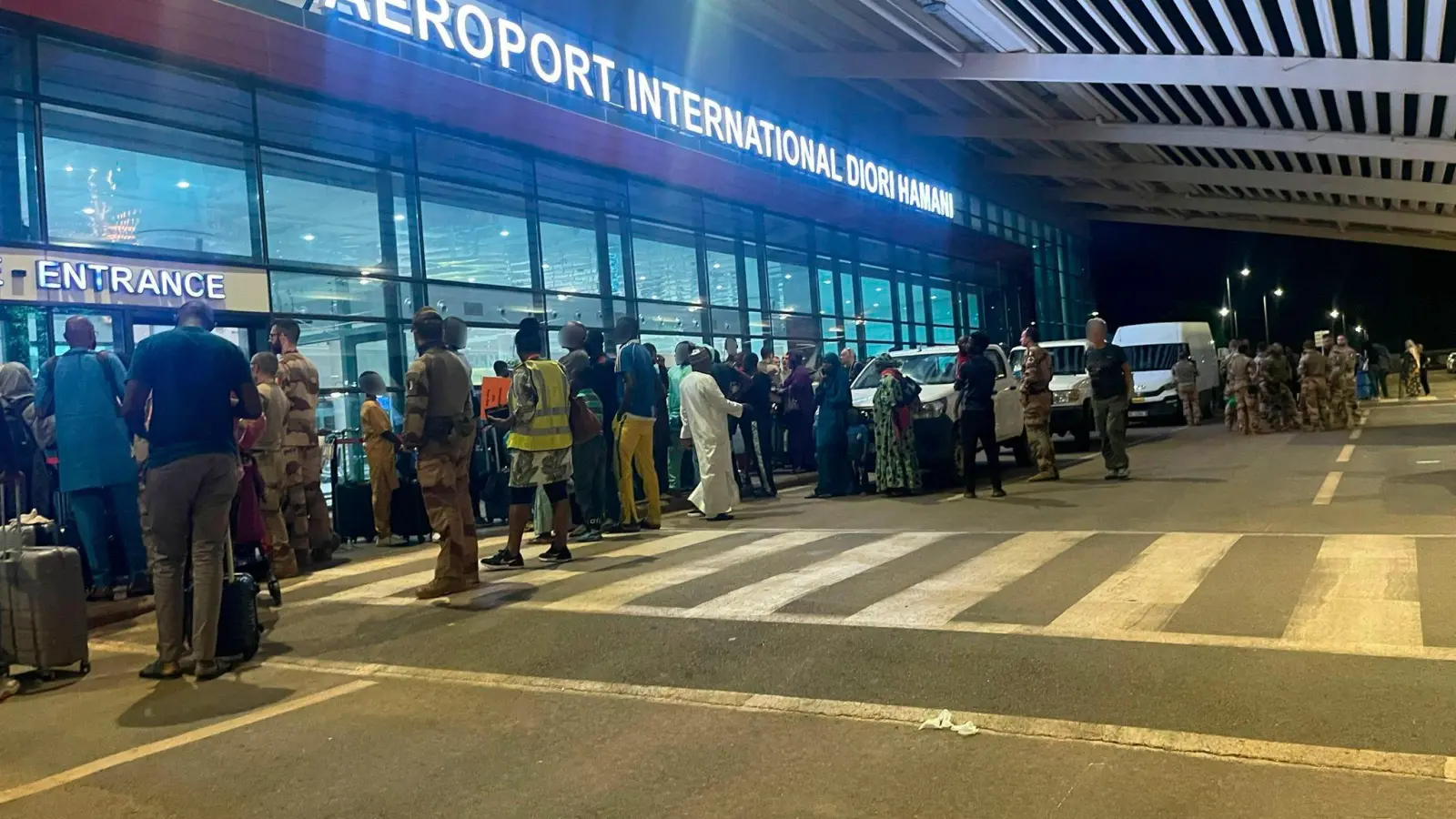 Menschen sind vor dem dem internationalen Flughafen von Niamey zu sehen. Knapp eine Woche nach dem Militärputsch im Niger hat Frankreich mit der Evakuierung seiner Staatsbürger aus dem westafrikanischen Land begonnen. (Foto: Generalstab der französischen Armee/dpa)
