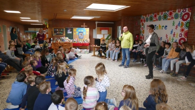 Kinder der Grundschule Dietersheim brachten Lebensmittel-Spenden und übergaben sie bei einer St. Martins-Feier mit Sieglinde Müller ( rechts) an Tomas Nicol (Mitte) von der Aischgründer Tafel. (Foto: Sylvia Fehlinger)