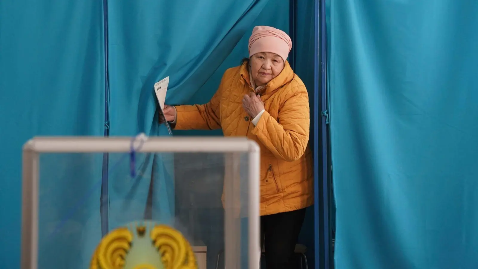Eine Frau verlässt eine Wahlkabine in Almaty. Unter dem Eindruck der schweren Unruhen des vergangenen Jahres fanden in Kasachstan in Zentralasien vorgezogene Parlamentswahlen statt. (Foto: Vladimir Tretyakov/NUR.KZ via AP/dpa)