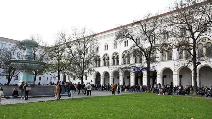 Studenten stehen vor dem Hauptgebäude der LMU. (Foto: Felix Hörhager/dpa/Archivbild)