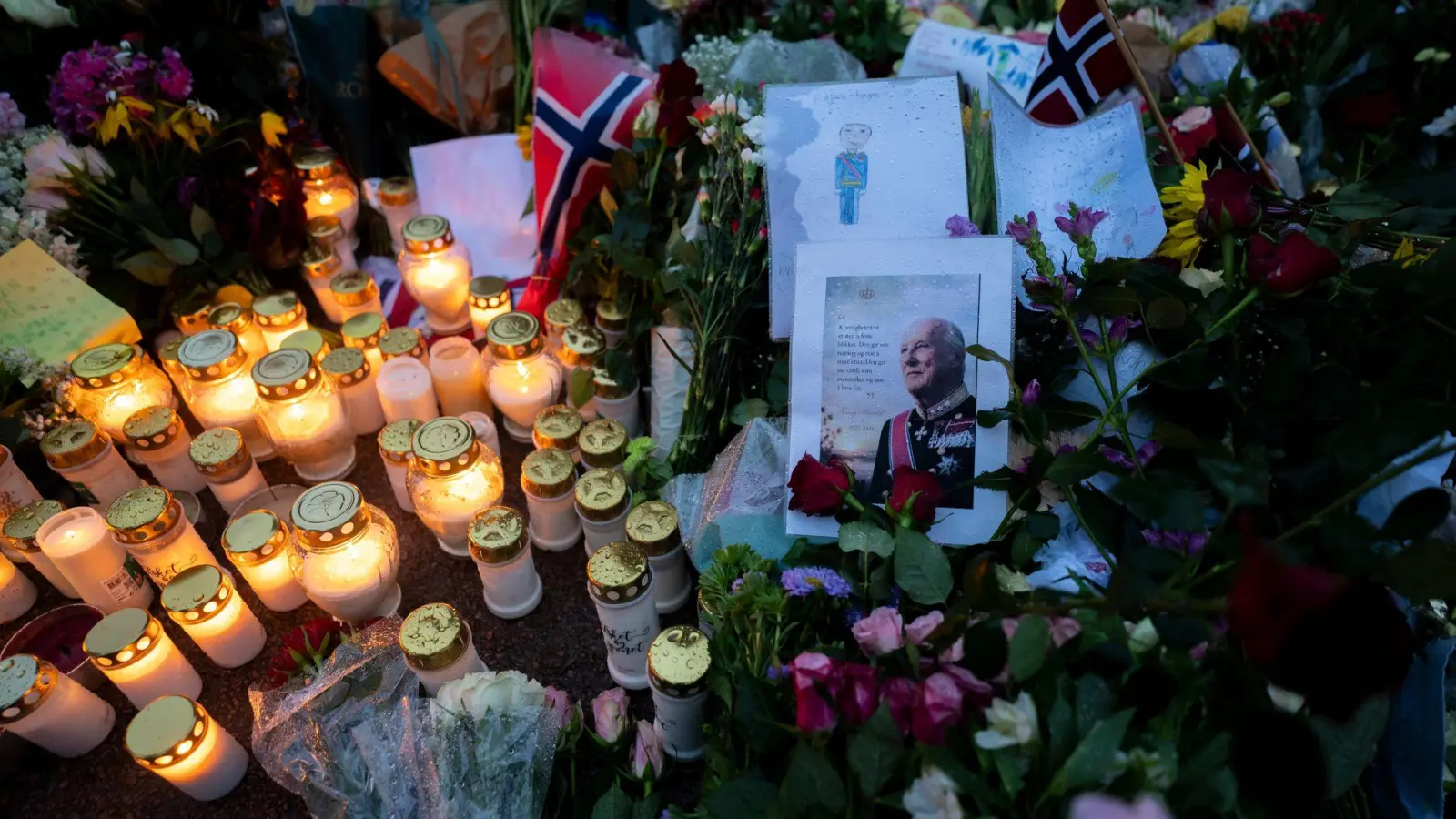 Blumen und Kerzen haben die Norweger für den beliebten König Harald V. vor dem Schloss in Oslo abgelegt.  (Foto: Cornelius Poppe/NTB/dpa)