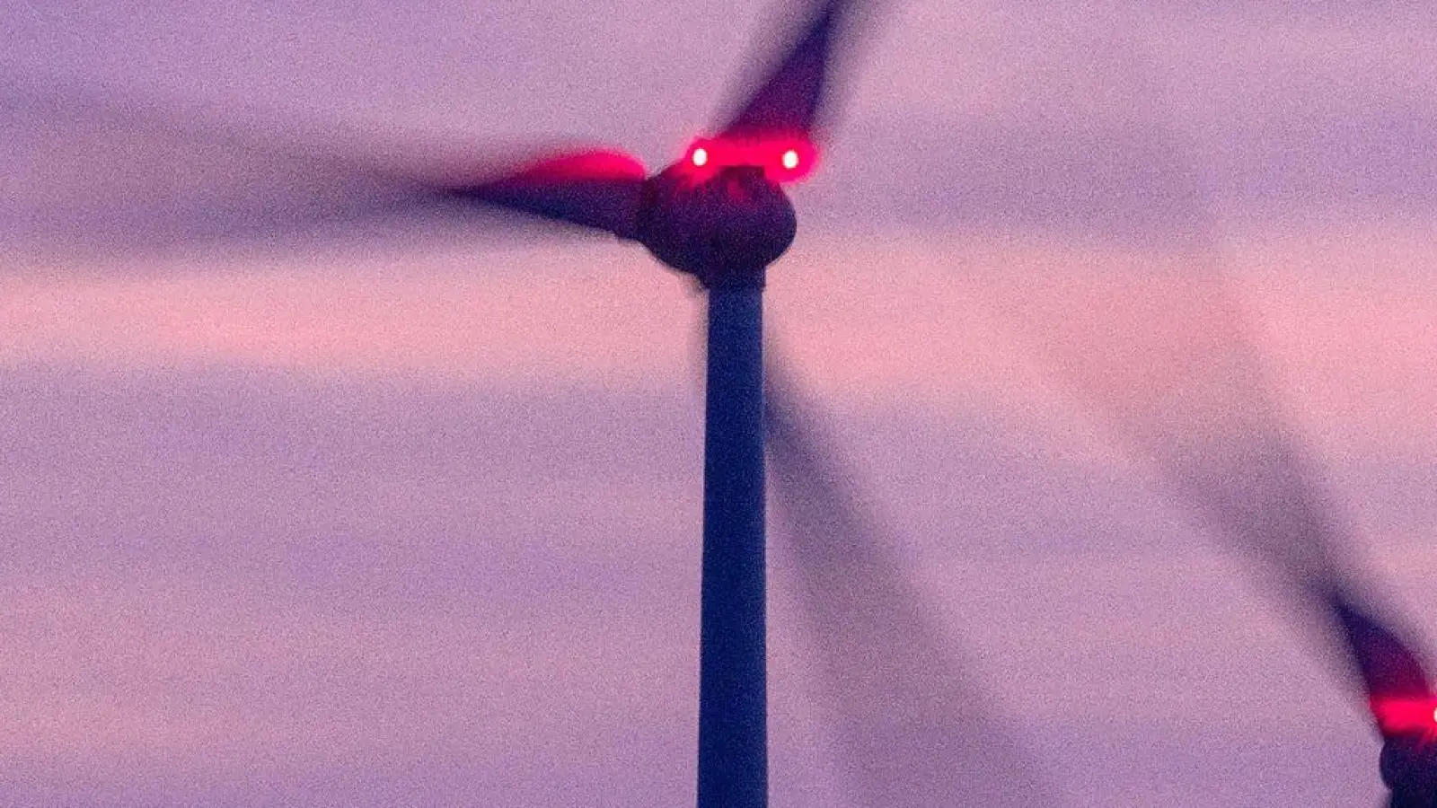 Mit Signallampen beleuchtete Windräder drehen sich nach Sonnenuntergang. (Foto: Jens Büttner/dpa/Archivbild)