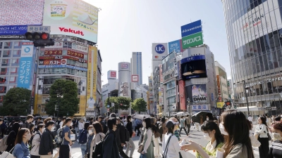 Menschen gehen in Japans Hauptstadt Tokio über eine Kreuzung. (Foto: kyodo/dpa)