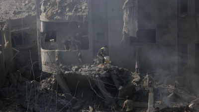 Palästinenser suchen in den Trümmern eines zerstörten Gebäudes in Bureij nach Überlebenden. (Foto: Mohammed Dahman/AP/dpa)