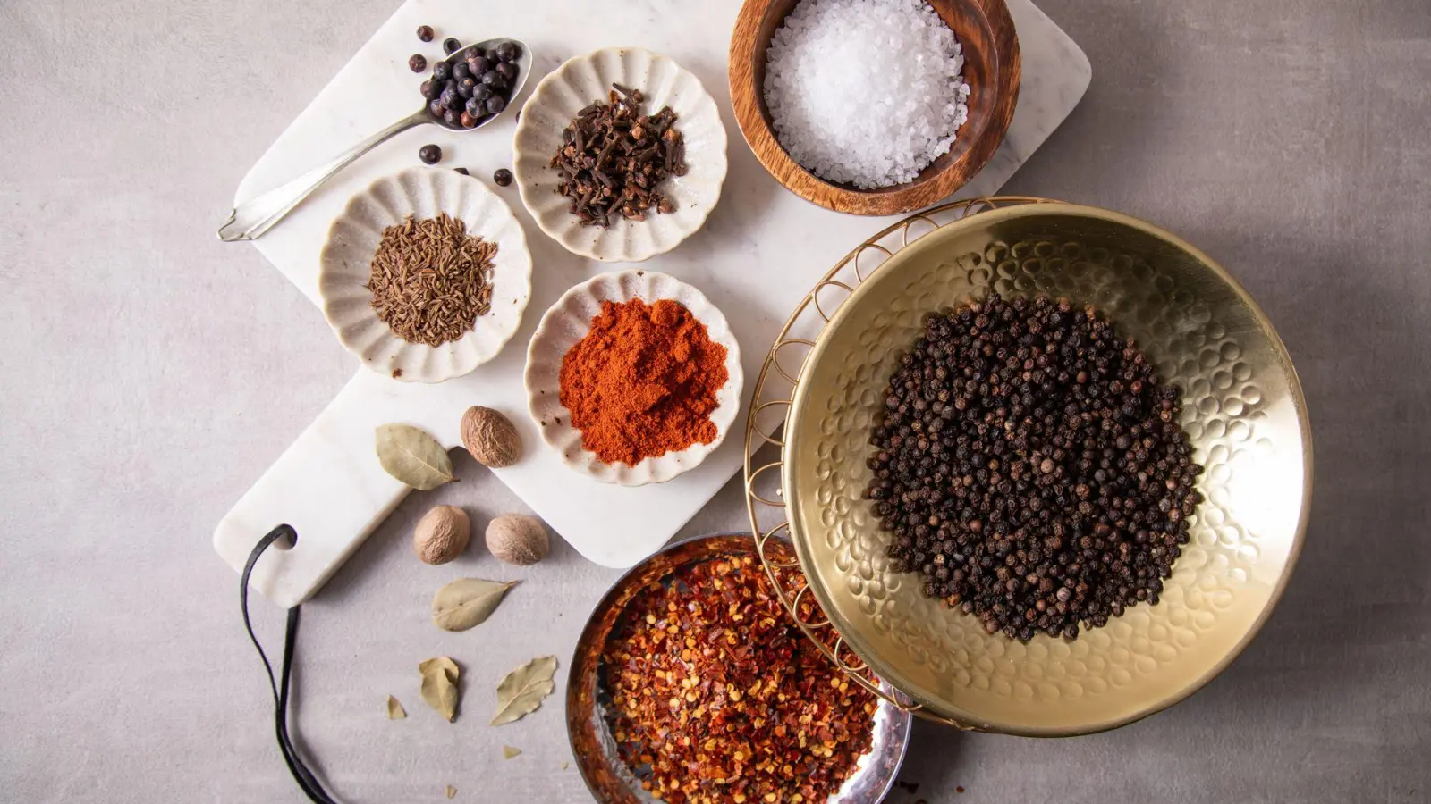 Zur Grundausstattung in der Küche gehören Salz, schwarzer Pfeffer, Chili-Flocken, Paprika edelsüß oder geräuchert, Kümmel, Nelken, Wachholderbeeren, Lorbeer und Muskatnuss. (Foto: Christin Klose/dpa-tmn)