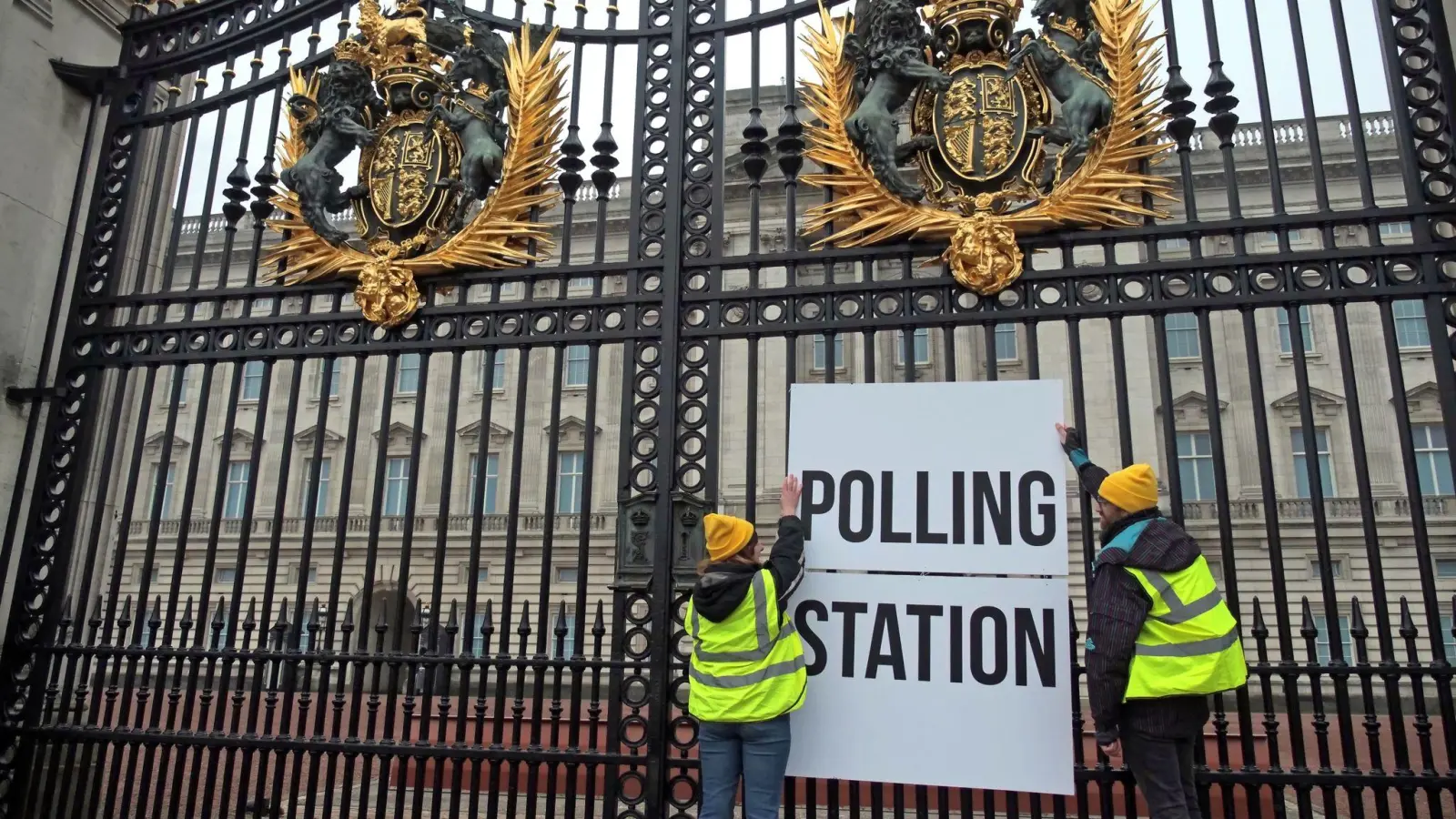 Anhänger der Kampagnengruppe Republic hängen ein Wahllokalschild ans Geländer des Buckingham Palace in London. (Foto: Aaron Chown/PA Wire/dpa)