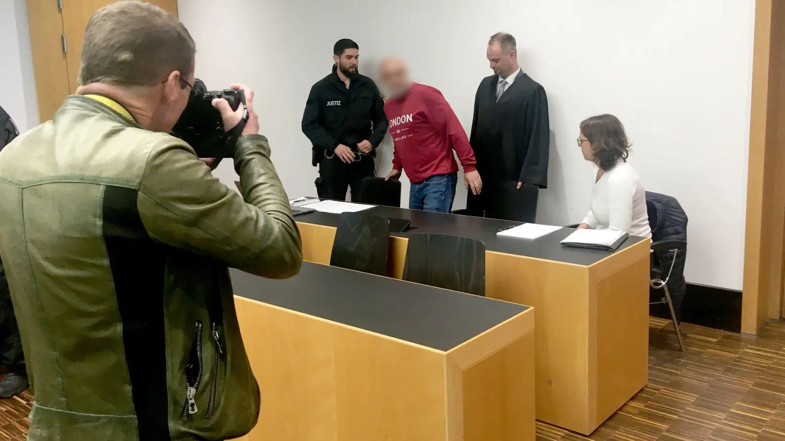 Weil er einen Priester mit Nacktfotos des Geistlichen erpresst hatte, ist der Angeklagte (Mitte) zu einer Haftstrafe auf Bewährung verurteilt worden. (Foto: Florian Kapfer/dpa)