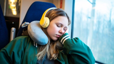 Nickerchen auf Reisen: Ein passendes Nackenkissen hilft dabei, dass der Hals nicht in eine unnatürliche Haltung gerät, wenn man im Sitzen wegdöst. (Foto: Maria Diachenko/Westend61/dpa-tmn)
