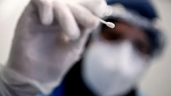 Ein Arzt hält ein Teststäbchen für die Entnahme einer Probe für einen Corona-Test in der Hand. (Foto: Britta Pedersen/dpa-Zentralbild/dpa/Symbolbild)