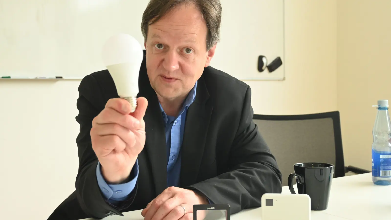 Eine LED-Lampe in der Hand und vor sich eine ins Handy integrierbare Fotozelle als LiFi-Modul sowie einen LiFi-Router: Forscher Harald Haas arbeitet an einer Licht-Revolution in der Datenübertragungstechnik. (F.: Judith Marschall)