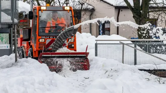 Mit einer Schneefräse wird ein Weg freigeräumt. (Foto: Armin Weigel/dpa)