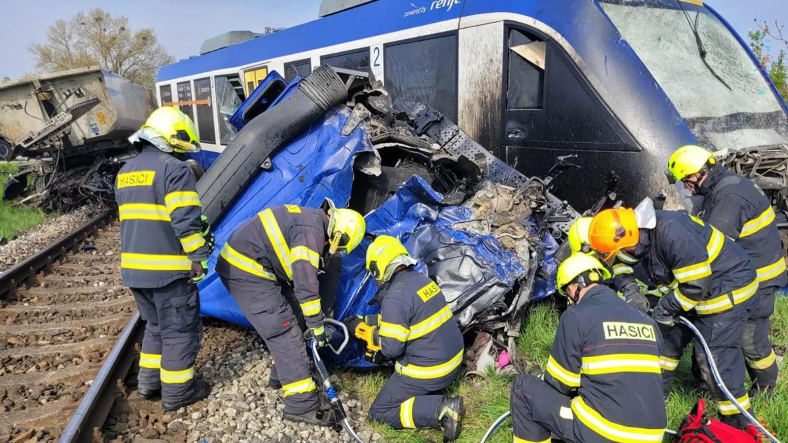 Feuerwehrleute arbeiten am Unglücksort, wo ein Personenzug und ein Lastwagen zusammengestoßen sind. Bei dem Unglück kam eine Person ums Leben, 21 Menschen wurden verletzt. (Foto: -/Feuerwehr- und Rettungsdienst Trnava/TASR/dpa)