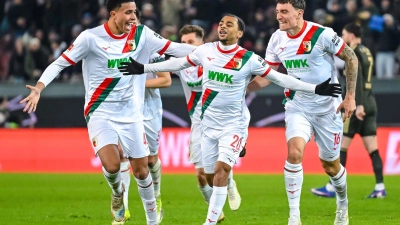 Alexis Claude-Maurice (M) jubelt nach seinem Traumtor mit seinen FCA-Kollegen. (Foto: Harry Langer/dpa)