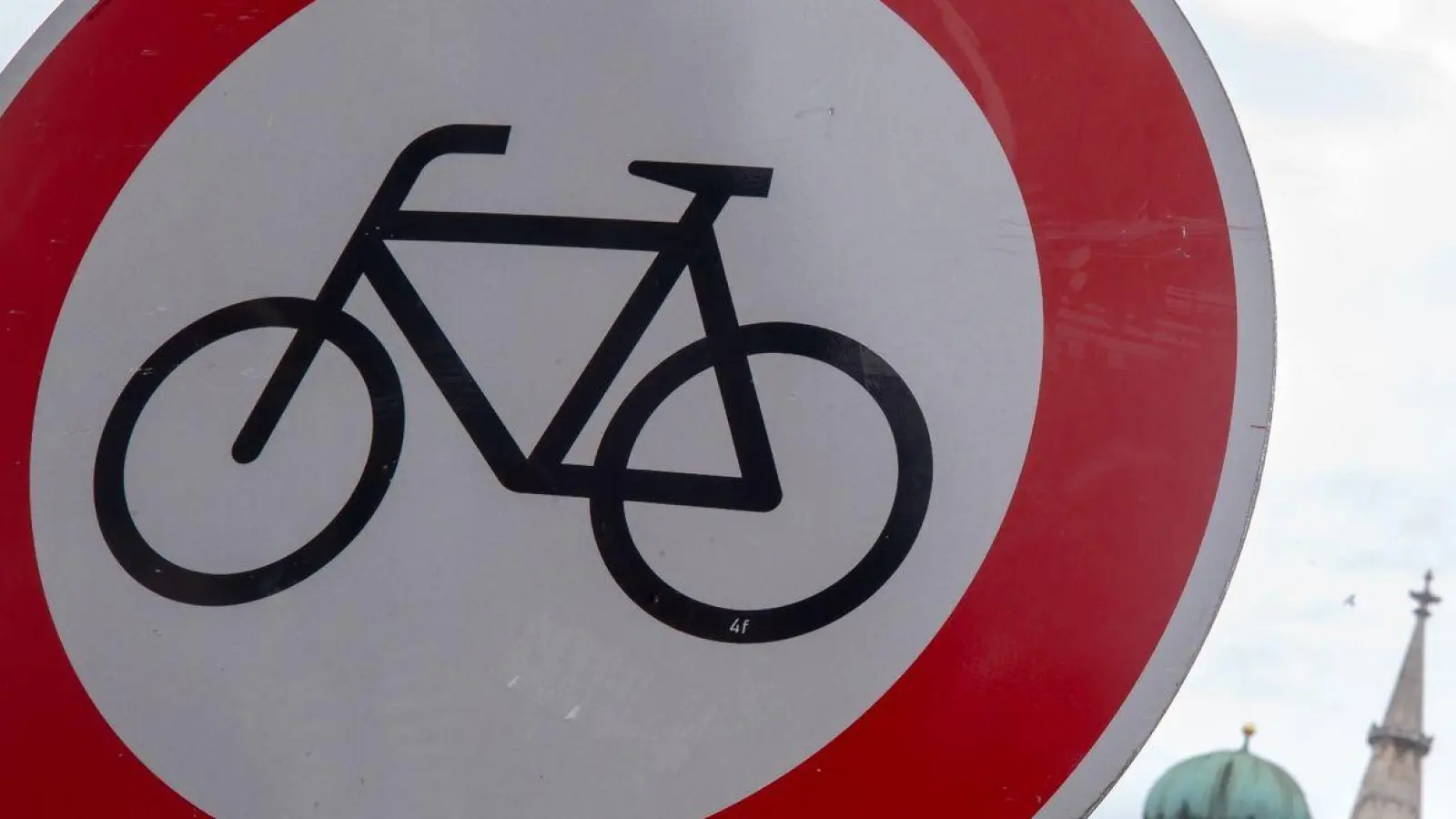 Ein „Radfahren verboten“-Verkehrsschild ist in der Innenstadt vor der Kulisse der Frauenkirche und des Rathauses zu sehen. (Foto: Peter Kneffel/dpa)