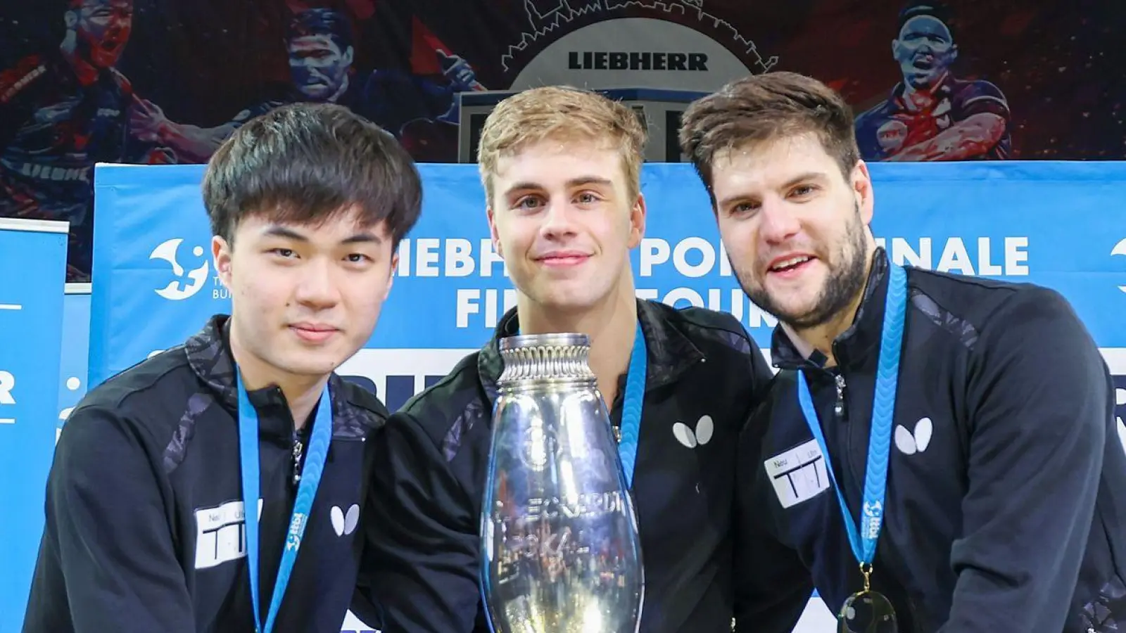 Lin Yun-ju (l-r), Truls Moregardh und Dimitrij Ovtcharov, alle von TTC Neu-Ulm, jubeln mit dem Champions-League-Pokal. In der Bundesliga spielt der Verein nicht mehr mit. (Foto: Joaquim Ferreira/dpa)