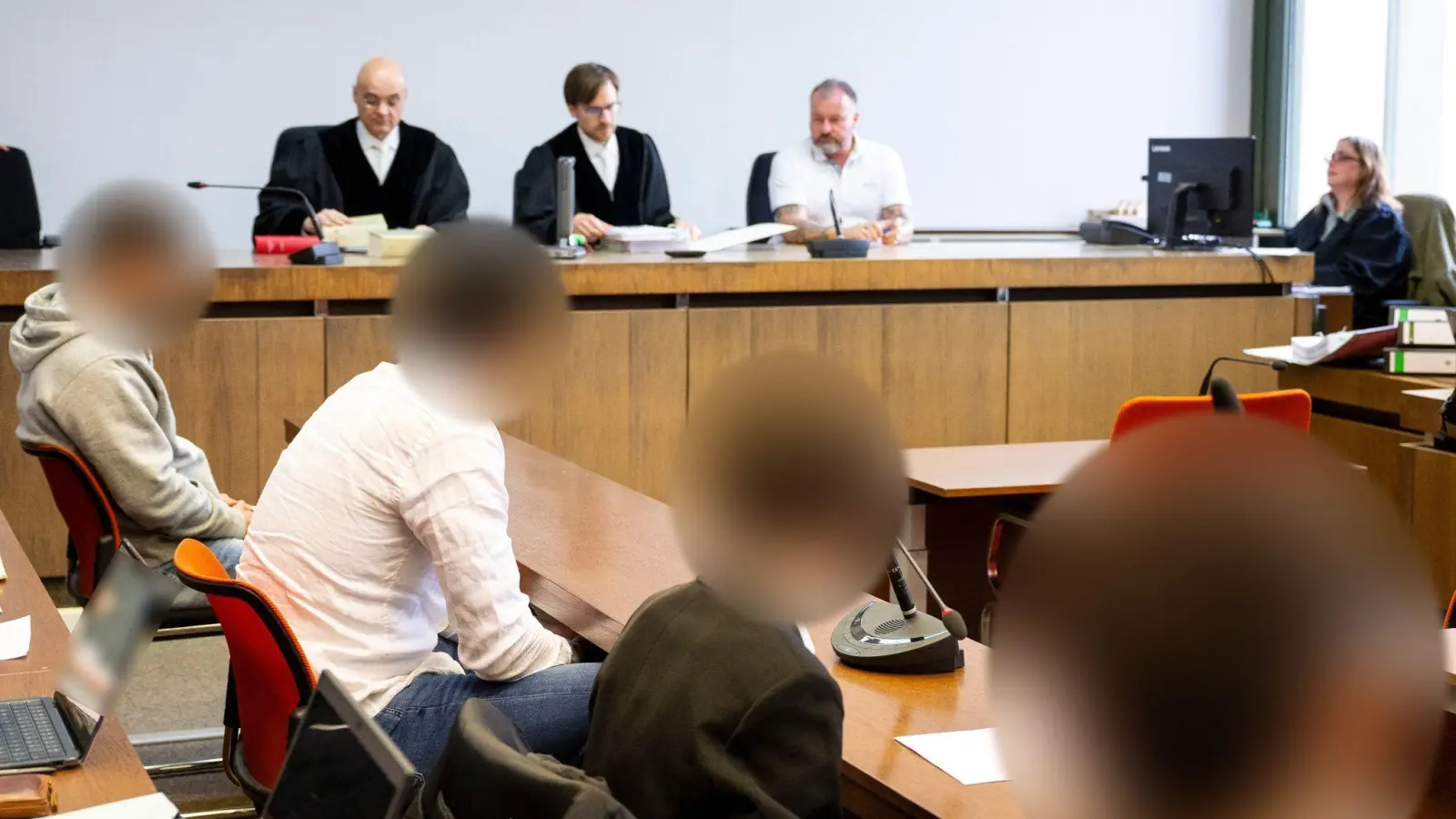 Vier Angeklagte sitzen zum Prozessauftakt wegen Raub und vorsätzlicher Körperverletzung im Gerichtssaal. (Foto: Lennart Preiss/dpa)
