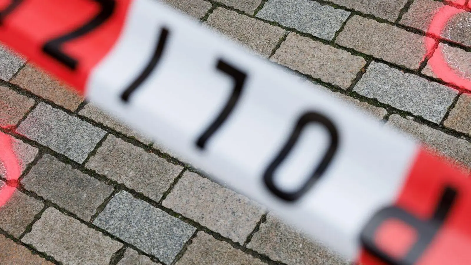 Markierungen der Kriminaltechnik am abgesperrten Tatort. (Foto: Friso Gentsch/dpa)