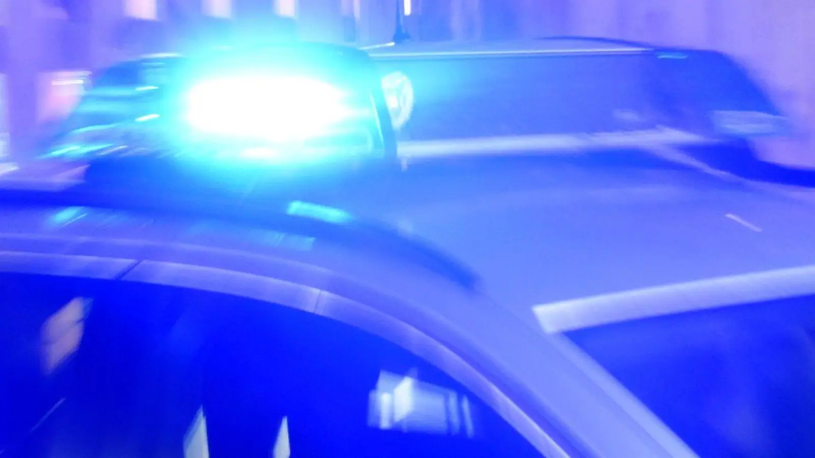 Ein Streifenwagen der Polizei steht mit eingeschaltetem Blaulicht auf der Straße. (Foto: Carsten Rehder/dpa)