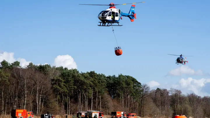 Hubschrauber der Polizei aus Niedersachsen (vorne) und aus Sachsen fliegen über einen Flugplatz. (Foto: Hauke-Christian Dittrich/dpa)