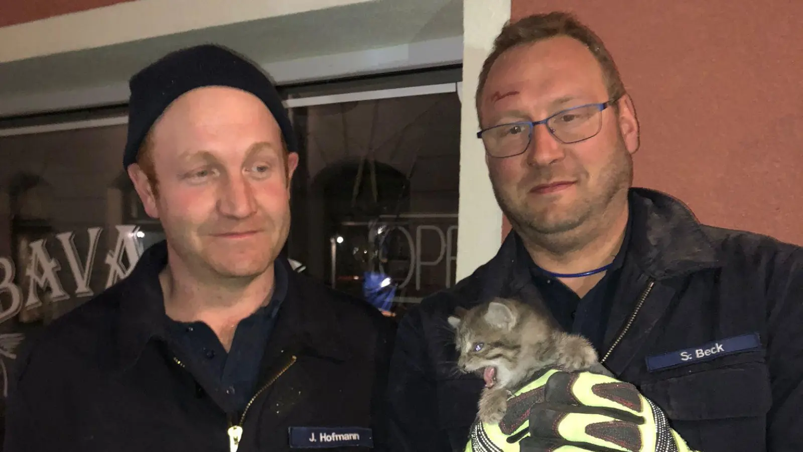 Die Feuerwehrleute Steffen Beck (rechts) und Johannes Hofmann nahmen das Katzenbaby nach der Rettung in der Platenstraße in Ansbach in Empfang. (Foto: Feuerwehr Ansbach)