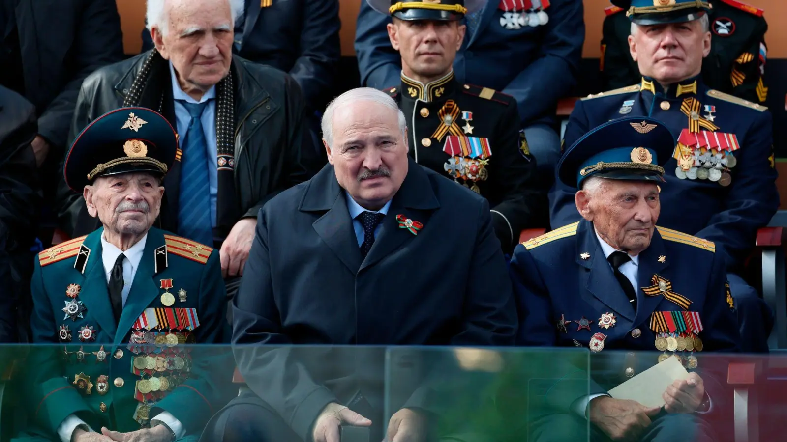 Der belarussische Präsident Alexander Lukaschenko (M.) beobachtet neben Veteranen die Militärparade zum Tag des Sieges anlässlich des 78. Jahrestages des Endes des Zweiten Weltkrieges auf dem Roten Platz in Moskau. (Foto: Gavriil Grigorov/Pool Sputnik Kremlin/AP/dpa)
