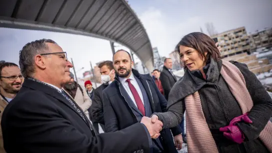 Außenministerin Annalena Baerbock (r.) begrüßt an der Ibar-Brücke Bedri Hamza, (l.) Bürgermeister von Mitrovica-Süd, und Milan Radojevic Bürgermeister von Mitrovica -Nord (M). (Foto: Michael Kappeler/dpa)