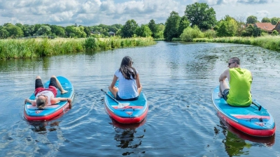 Relaxen auf dem Wasser: Mit etwas Übung kann man sich auf dem SUP-Board auch mal langmachen. (Foto: Max Wiesenbach/Stade Marketing und Tourismus GmbH/dpa)