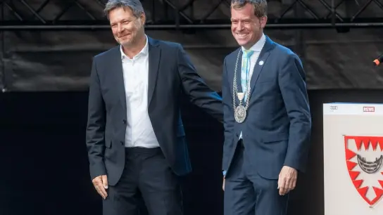 Robert Habeck (Grüne) und Ulf Kaempfer (SPD), Kieler Oberürgermeister, stehen zur Eröffnung der Kieler Woche 2022 auf einer Bühne. (Foto: Markus Scholz/dpa)