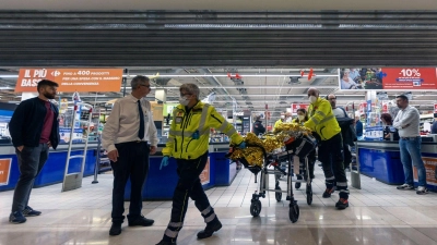 Rettungskräfte transportieren eine verletzte Person aus dem Supermarkt. (Foto: Uncredited/LaPresse/AP/dpa)
