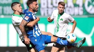 Der Fürther Damian Michalski (l) kämpft mit Fabian Schleusener vom Karlsruher SC um den Ball. (Foto: Daniel Karmann/dpa)