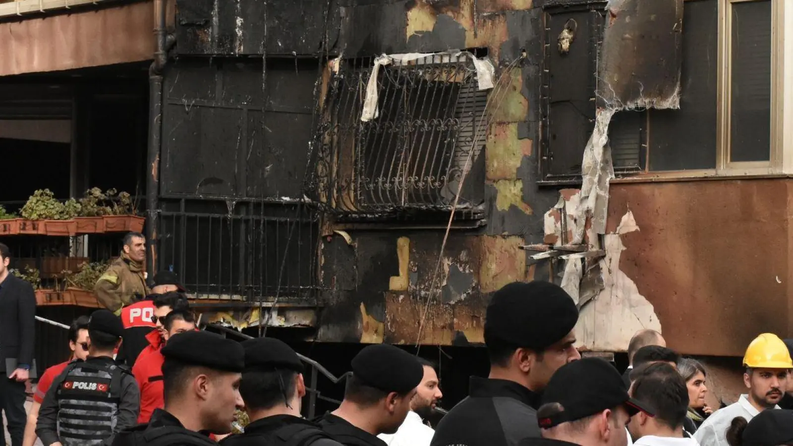 Einsatzkräfte stehen nach einem Brandausbruch vor einem teilweise verbrannten Gebäude. (Foto: Safar Rajabov/XinHua/dpa)