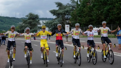 Ausnahmefahrer Tadej Pogacar feiert auf der Schlussetappe mit seinen Teamkollegen.  (Foto: Mosa'ab Elshamy/AP/dpa)